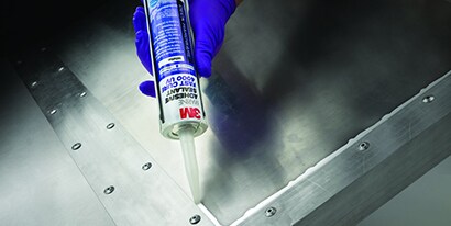 Teknisyenin metal-metal yapıştırıcıyla köşede sızdırmazlık sağlaması
