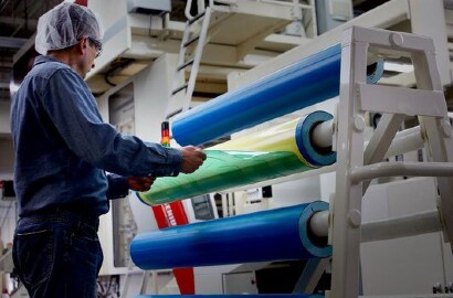 Silindir üzerindeki bir fleksografik klişeden fleksografik klişe çıkaran bir çalışan resmi
