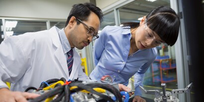 3M Endüstriyel Topluluğu. Bir laboratuvarda robotik bölümleri inceleyen iki mühendisin görüntüsü.
